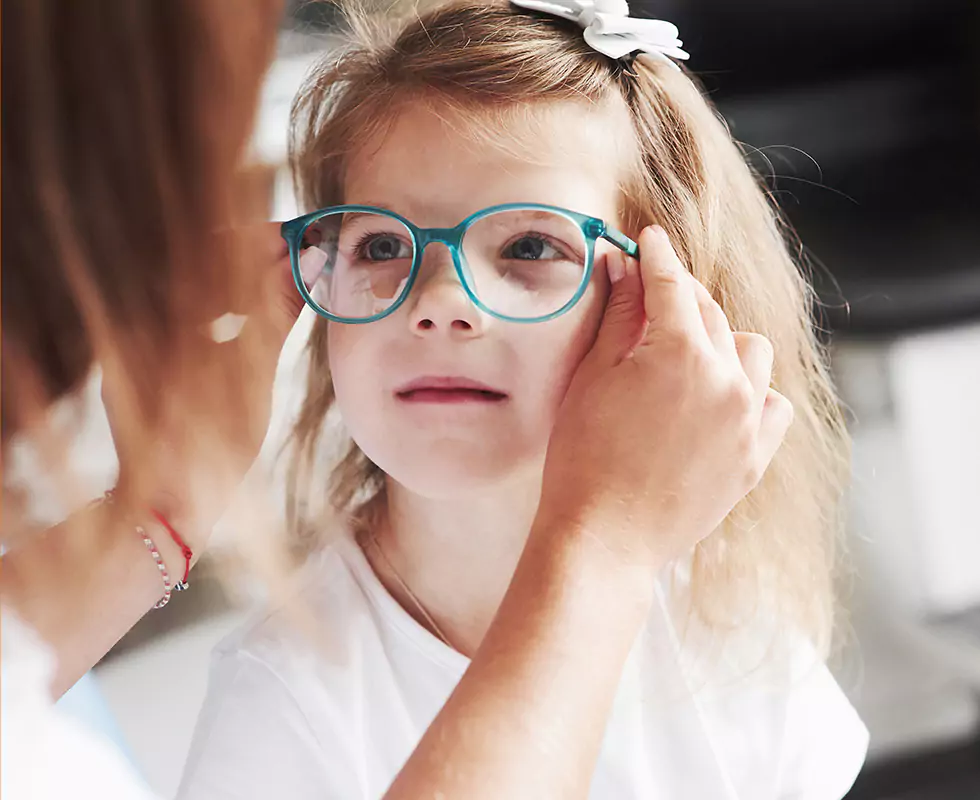 Einem Mädchen wird eine Brille angepasst